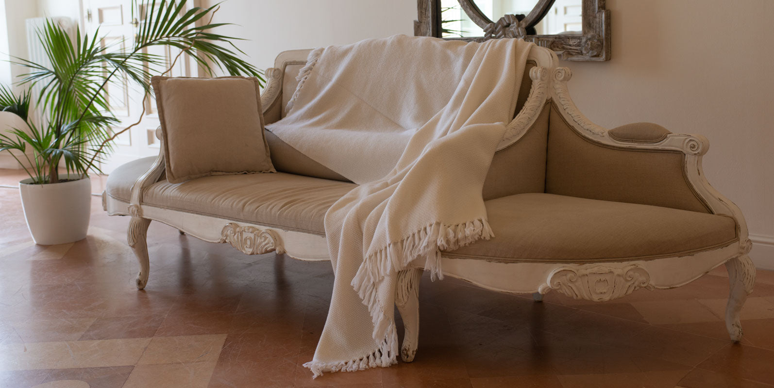 Cashmere throw in white draped over a chaise longue
