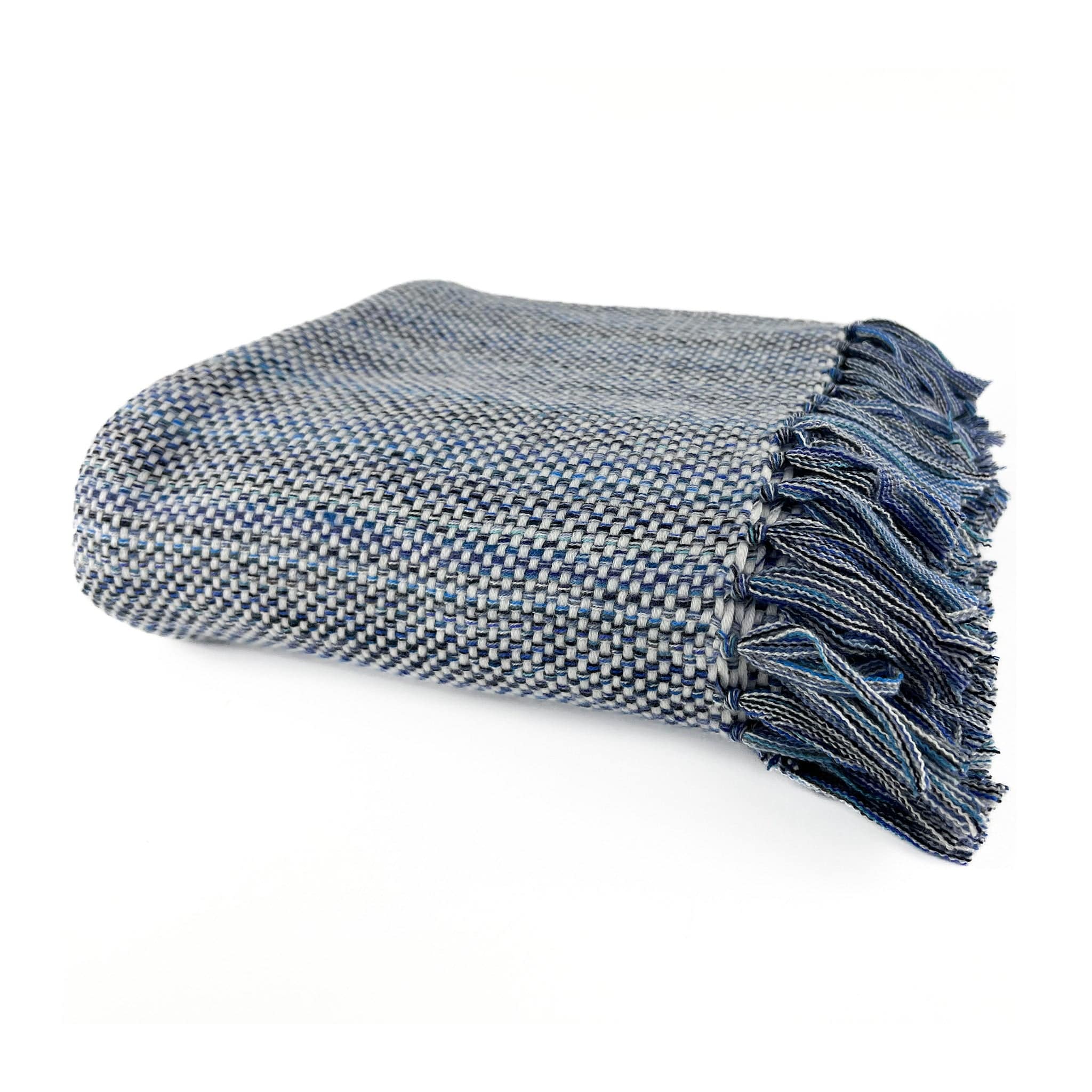 An Italian made Cashmere throw with a white weft and different shades of blue warp, folded on a white background with handknotted multiple shades of blue tassels showing in front right hand side